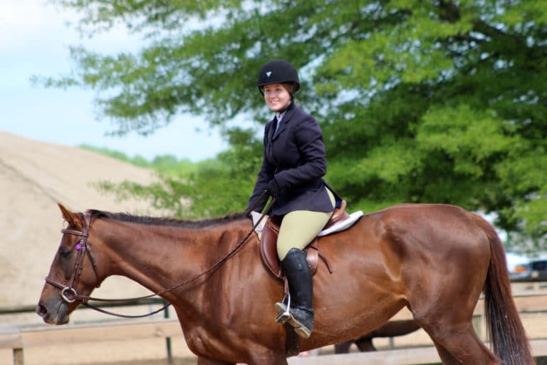 A rider is smiling while riding a horse